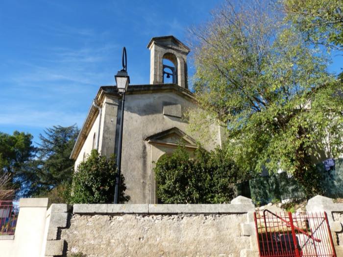 L'église de Lecques et son clocher-mur, derrière un muret de pierre sèche.